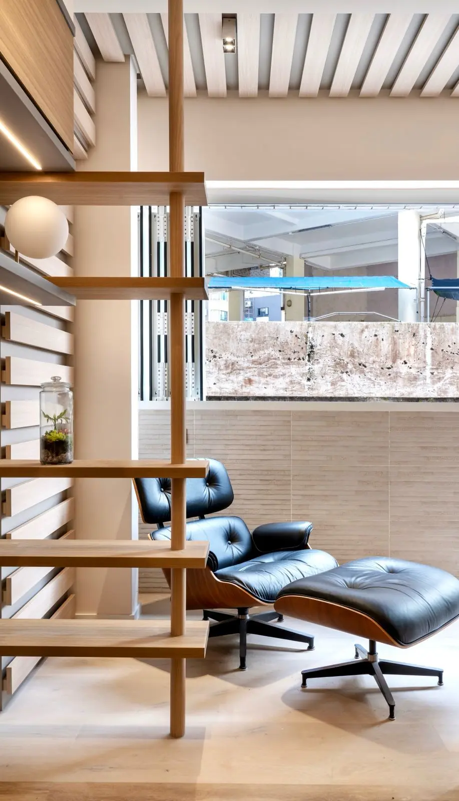 Window-side lounge chair beside timber display shelving