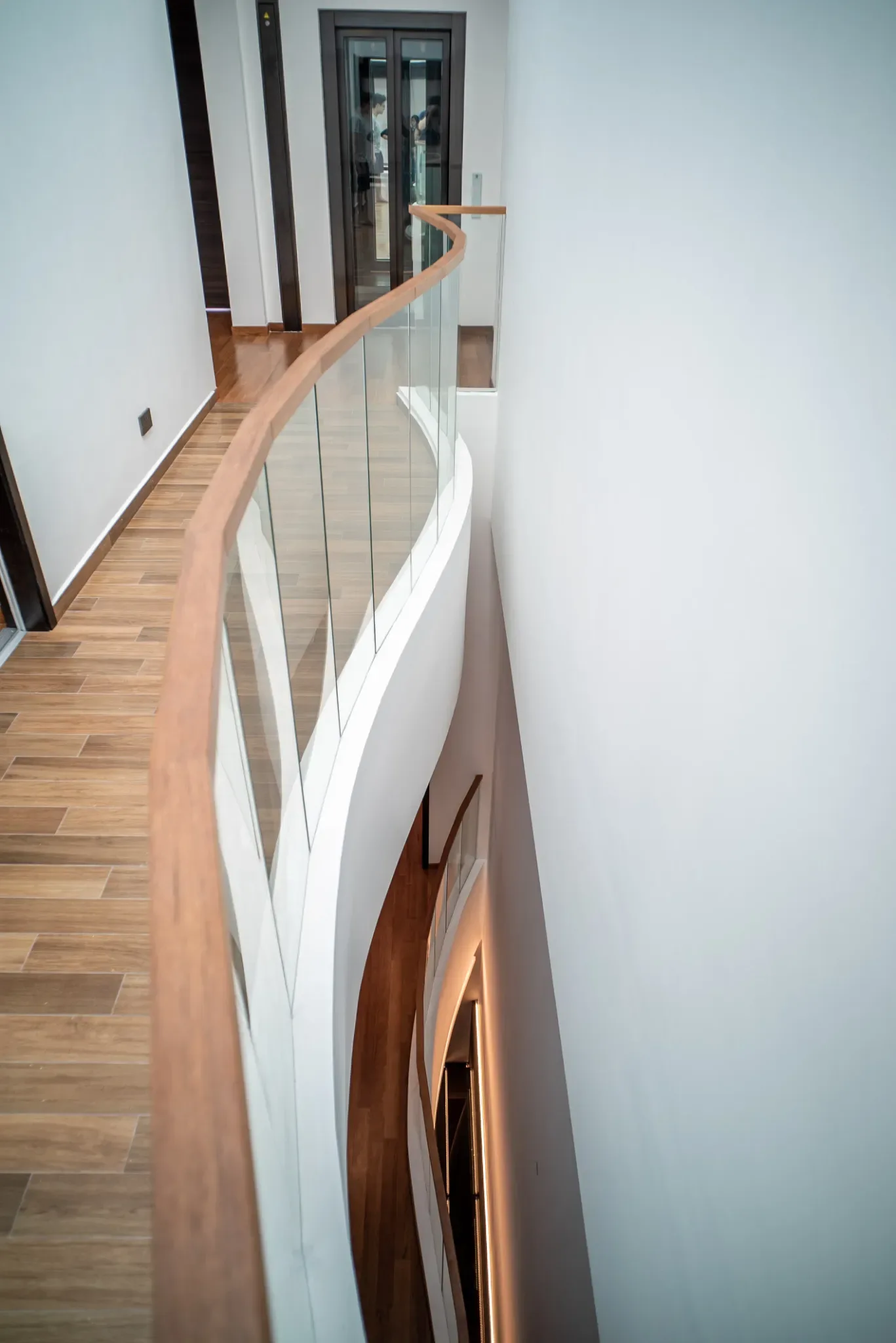 J Concept Designers &mdash; curved glass balustrade upper landing looking down stairwell