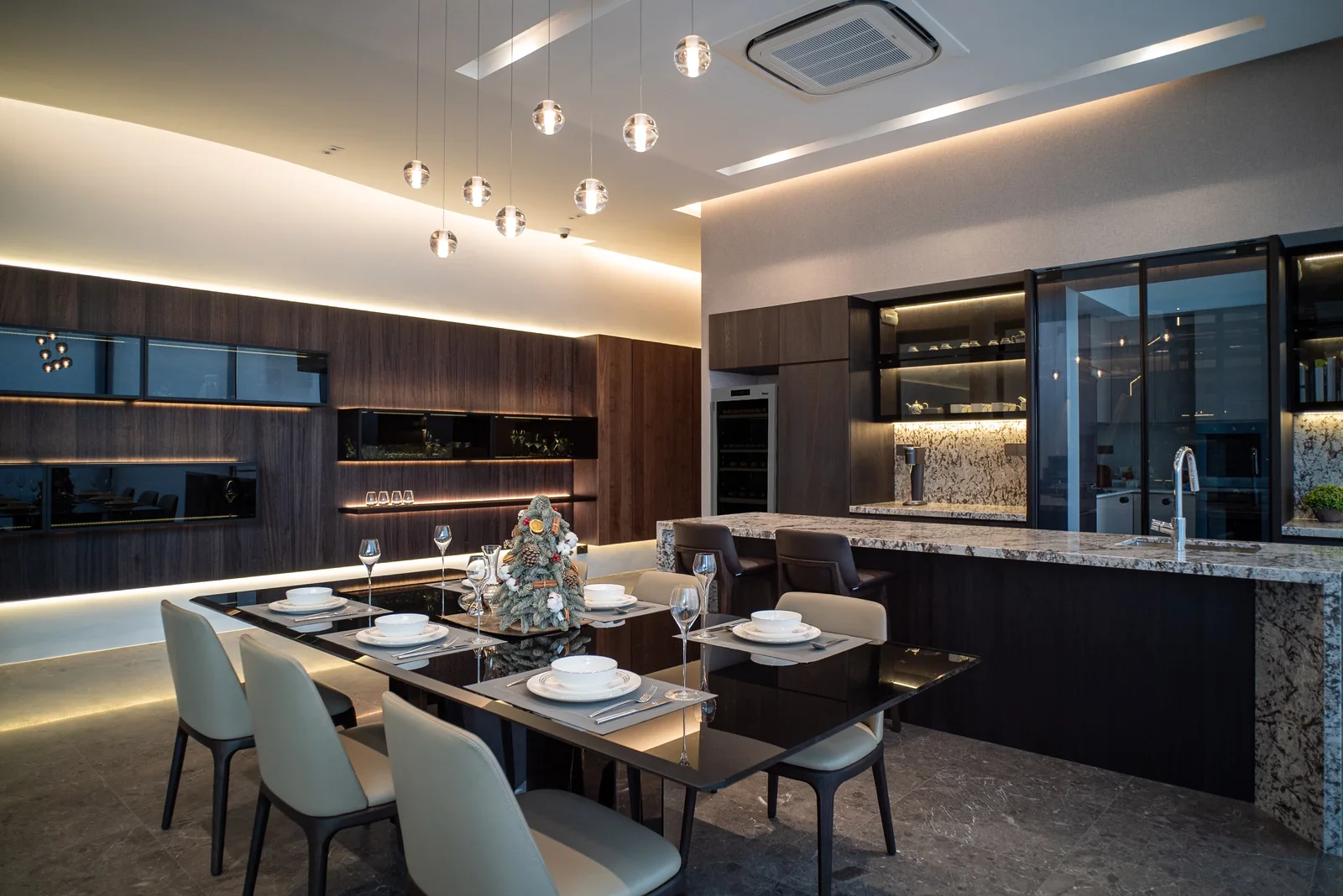 J Concept Designers &mdash; dining and dry kitchen wide view with globe pendants and stone island