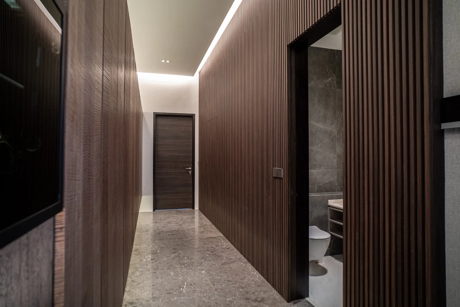J Concept Designers &mdash; fluted dark timber hallway with marble floor