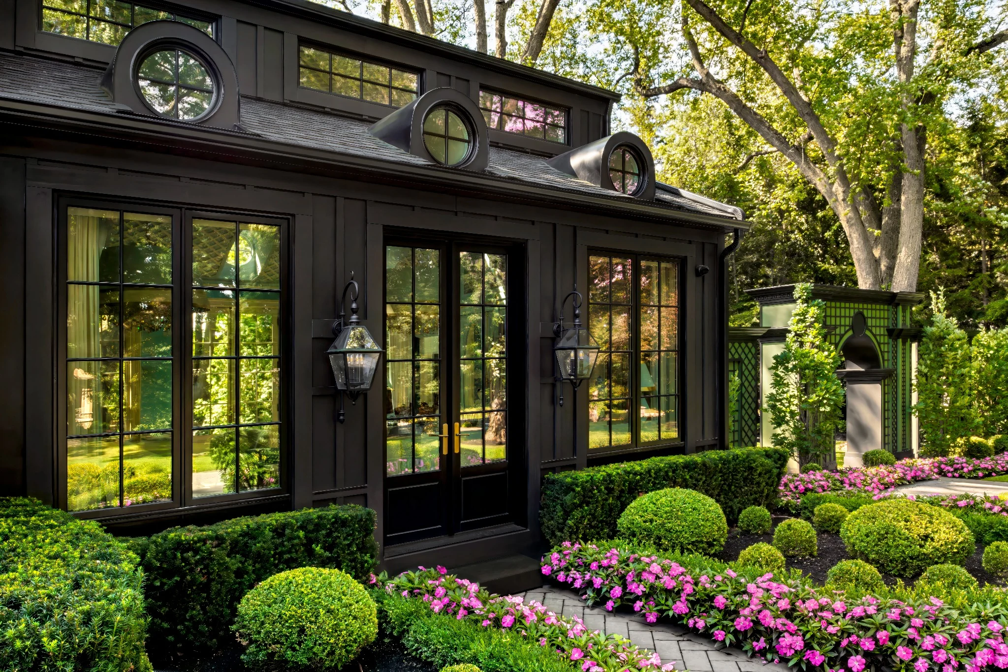Lori Morris Design &mdash; dark painted exterior facade with porthole windows, oversized lanterns and formal garden planting