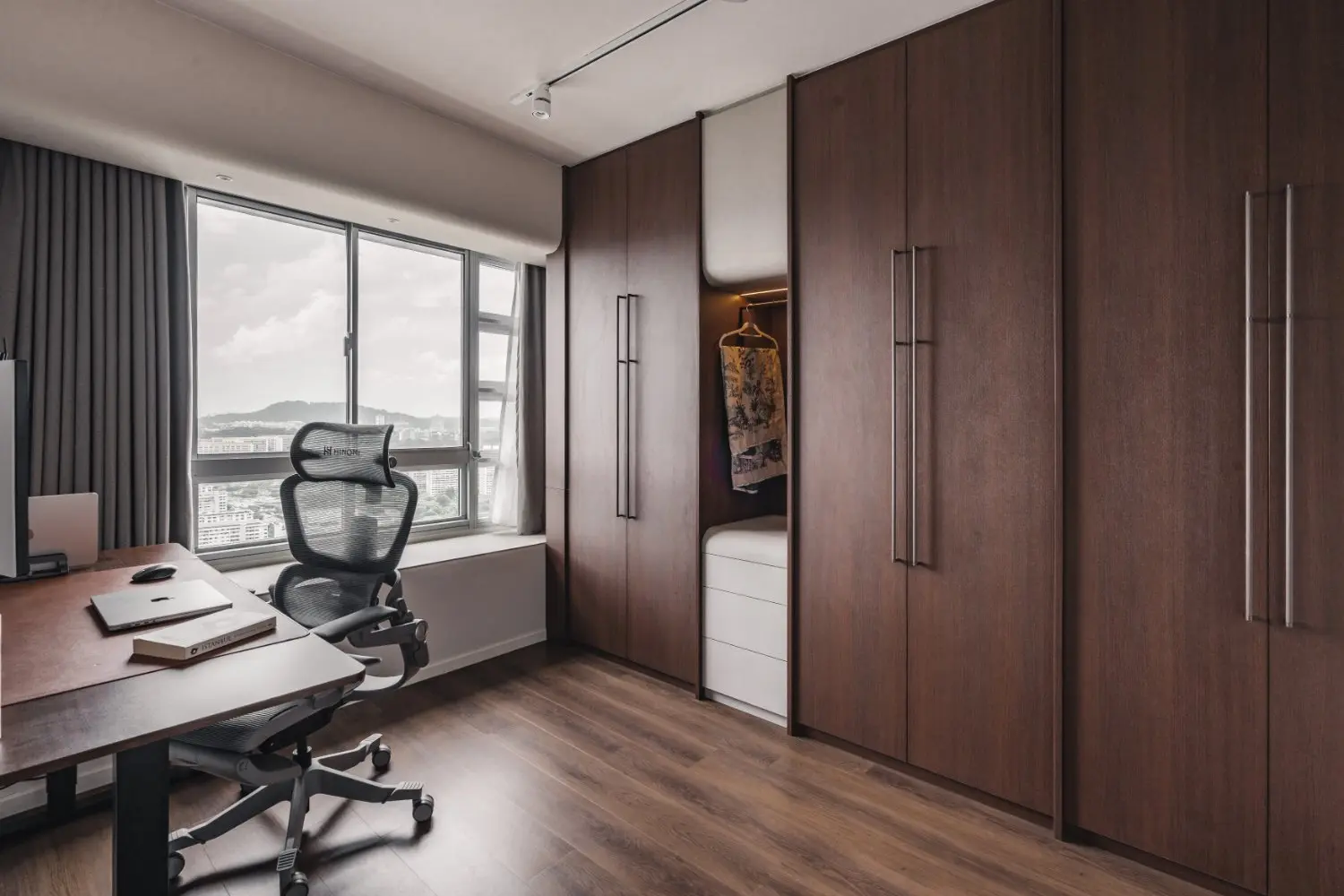 Home office with window-facing desk and full-height timber storage