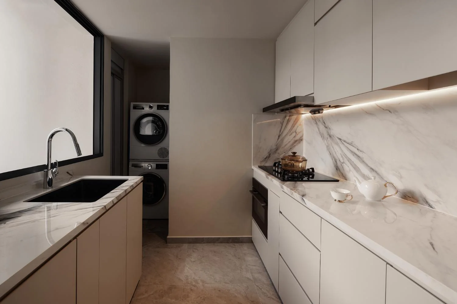 Light-toned kitchen with integrated appliances at Esparina Residences