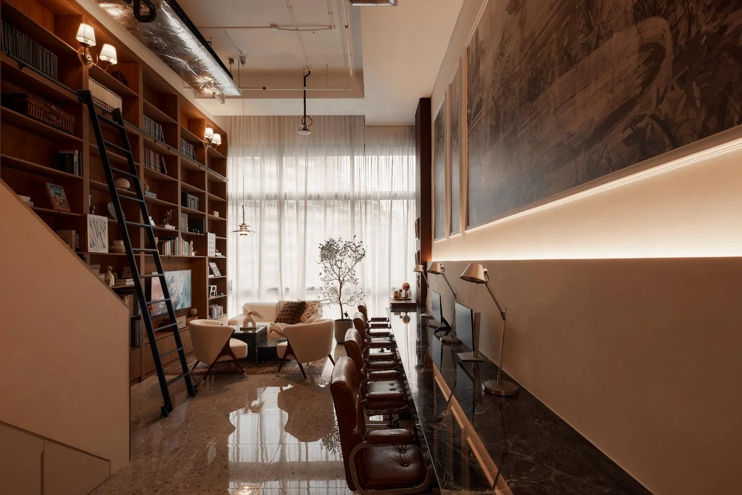RENOSTUD.IO loft office showing the long workstation and full-height bookshelf