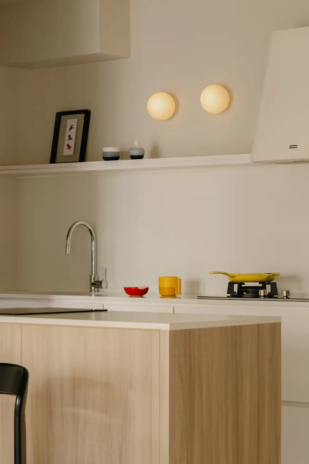Minimal kitchen with pale timber cabinetry and white open shelf