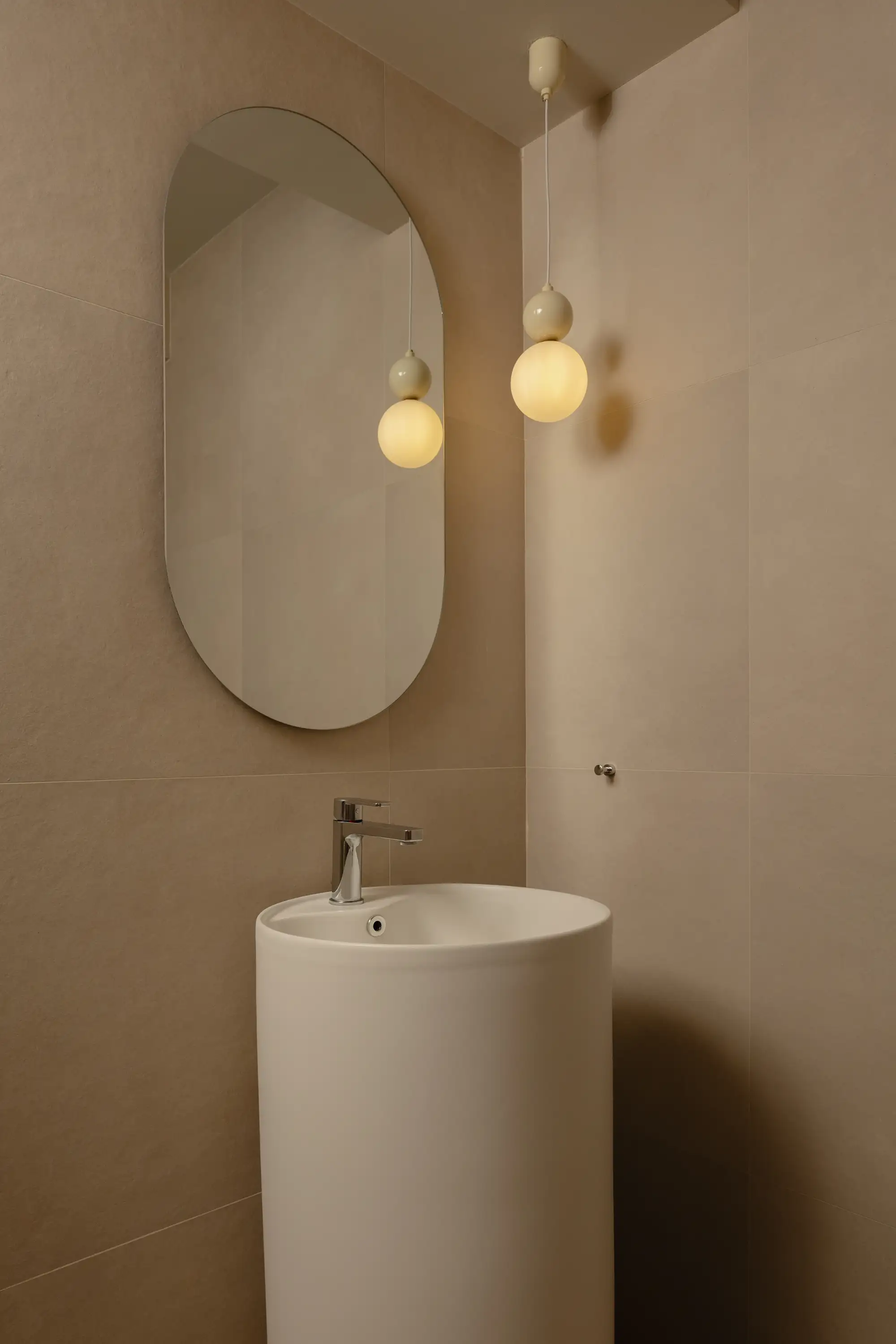 Vanity area with freestanding basin, organic mirror and pendant lights