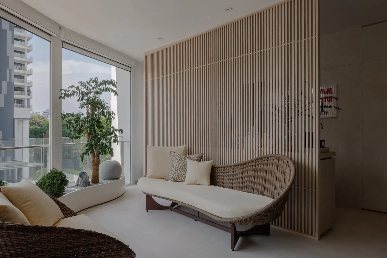 Balcony seating beside a full-height fluted privacy screen